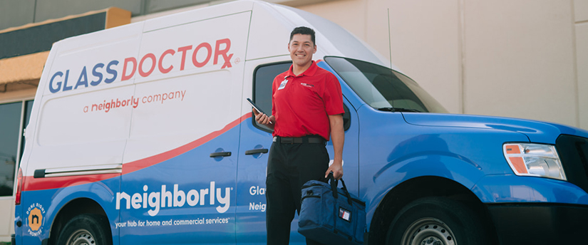 Glass Doctor of Tyler, TX Glass Doctor technician at the door with the glass doctor van parked out front and 60 years of Glass Doctor logo