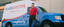 Glass Doctor technician at the door with the glass doctor van parked out front and 60 years of Glass Doctor logo