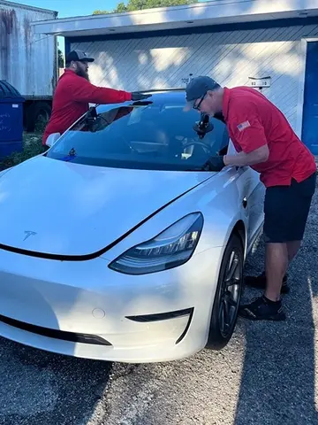 Glass Doctor of Tampa Bay auto glass specialists replacing the windshield on a white Tesla.
